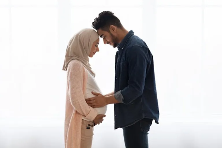 Pregnant couple embracing the moment after successful IVF treatment